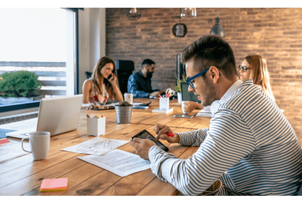 En grupp av yrkesverksamma arbetar tillsammans i ett öppet och inspirerande coworking-utrymme