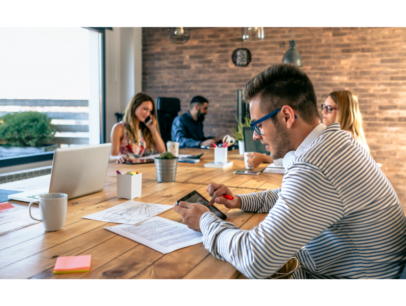 En grupp av yrkesverksamma arbetar tillsammans i ett öppet och inspirerande coworking-utrymme